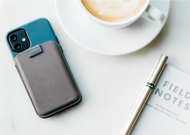 The MagSafe Wally Junior for iPhone shown sitting on a table with a cappuccino and notebook