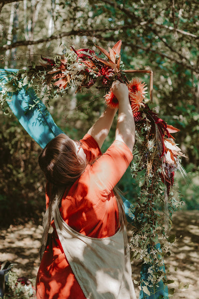 Laura creating the arbor florals for this woodland wedding ceremony.