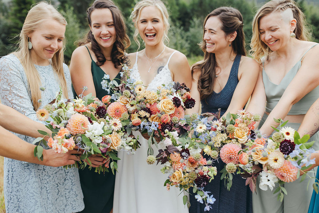 Lovely bride with her bridesmaids and colorful summer florals