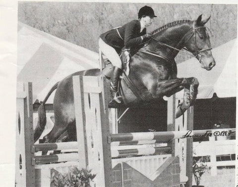Stacia Klein Madden and Outrageous jumping over an oxer.
