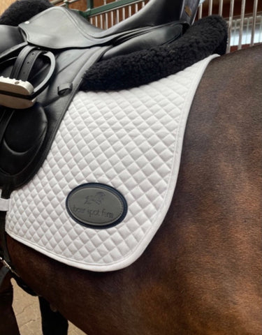 Close up of the personalization on a Custom Essential Dressage Square Pad showing the Bear Spot Farm logo.