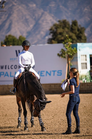 Zoie Brogdon riding in a clinic with Jessica Springsteen.