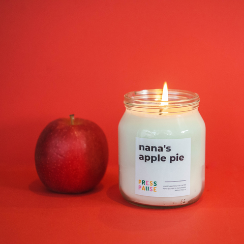 A natural soy wax candle with a red apple