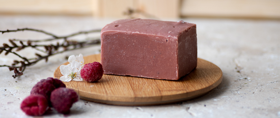 A large soap bar on a background with red raspberries