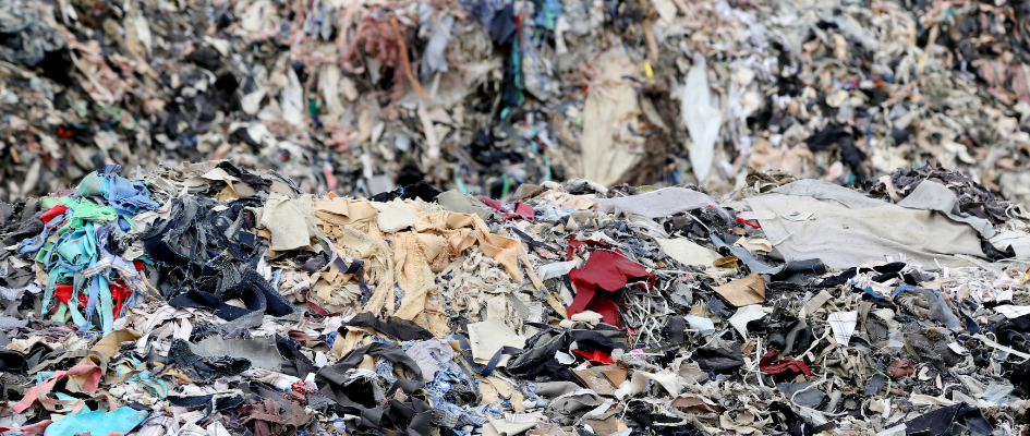 The Environmental Toll of Fast Fashion. Pile of old clothes.