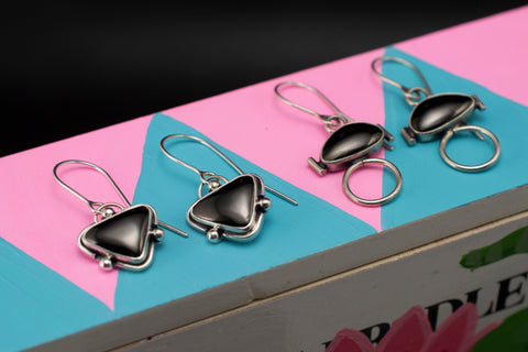 hematite earrings on colorful painted background
