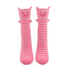 Shown on a foot mold from a different angle, a pair of Foot Traffic, pink and white cotton women's crew socks with three dimensional pattern of cute pig