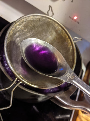 purple egg dye in metal spoon
