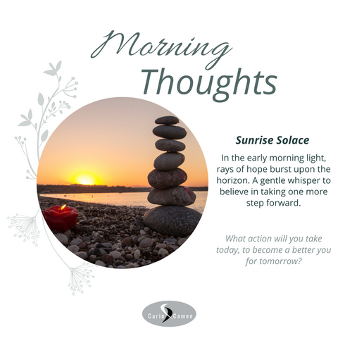 Sunrise with rocks piled on top of each other and a candle.