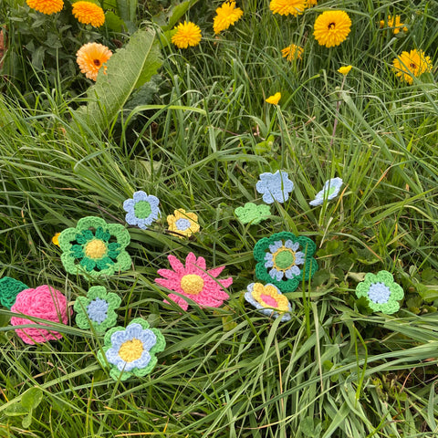 Crocheted flowers made with Kremke Soul Wool Karma Cotton recycled yarn in the grass at Chesterblade Hills