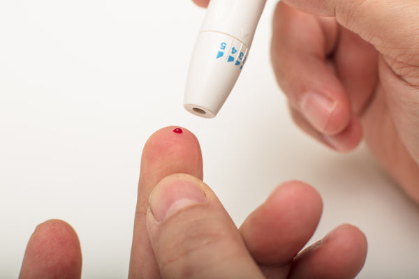 obtaining finger prick blood sample for cholesterol test 