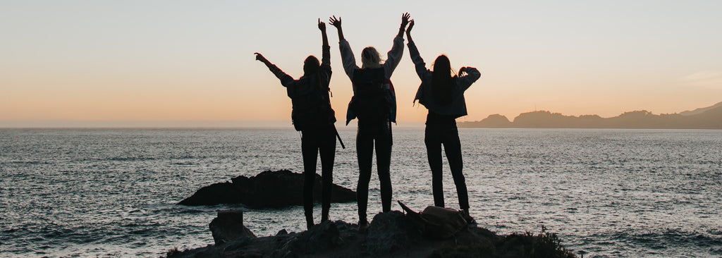 3 Friends on a rock enjoying friendship, not alone