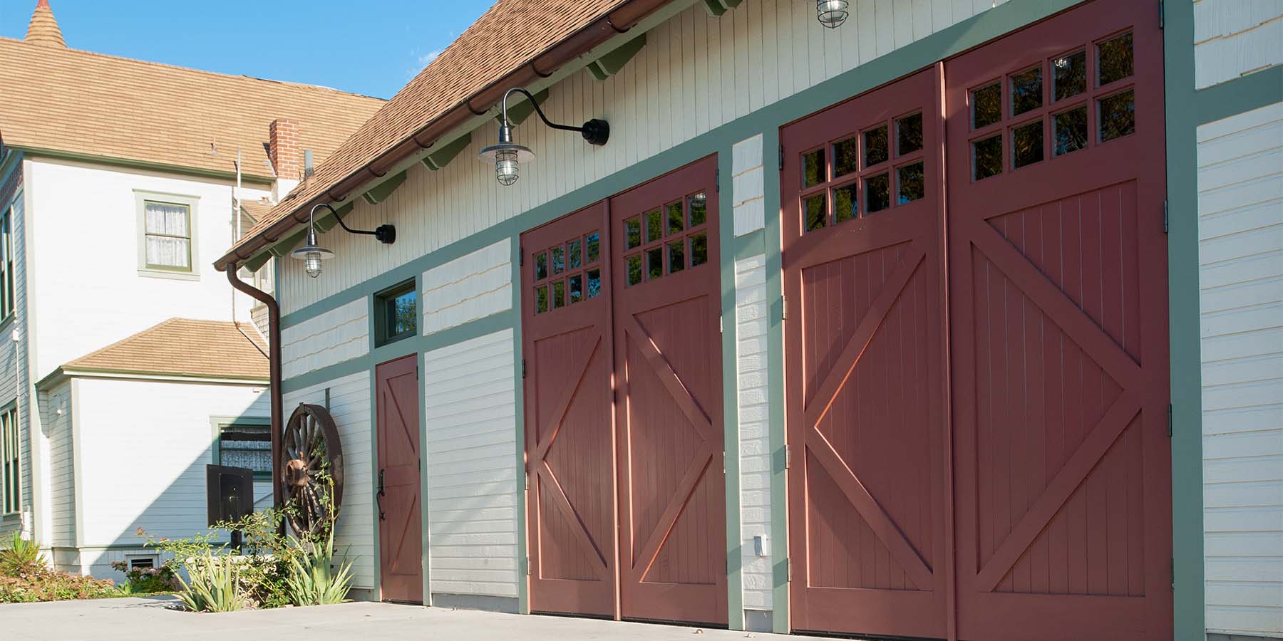 Two red carriage doors and a red entry door at Founder's Park.