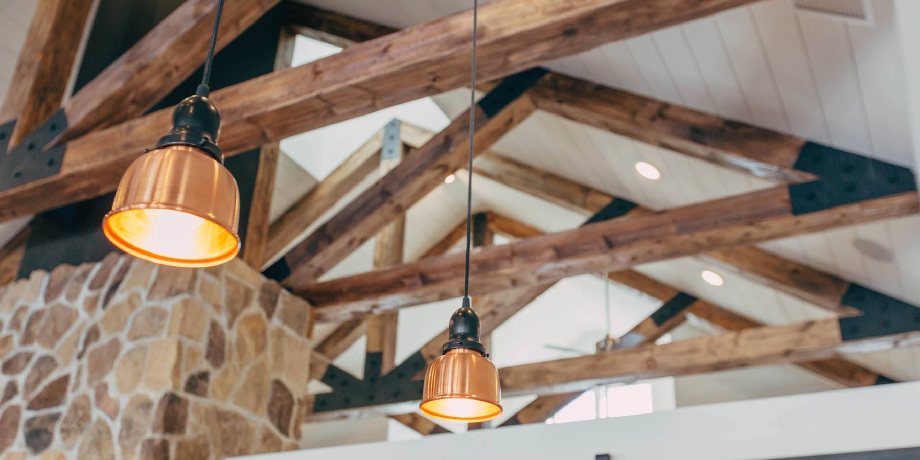 Ceiling wood beam  with two bronze hanging lamps.