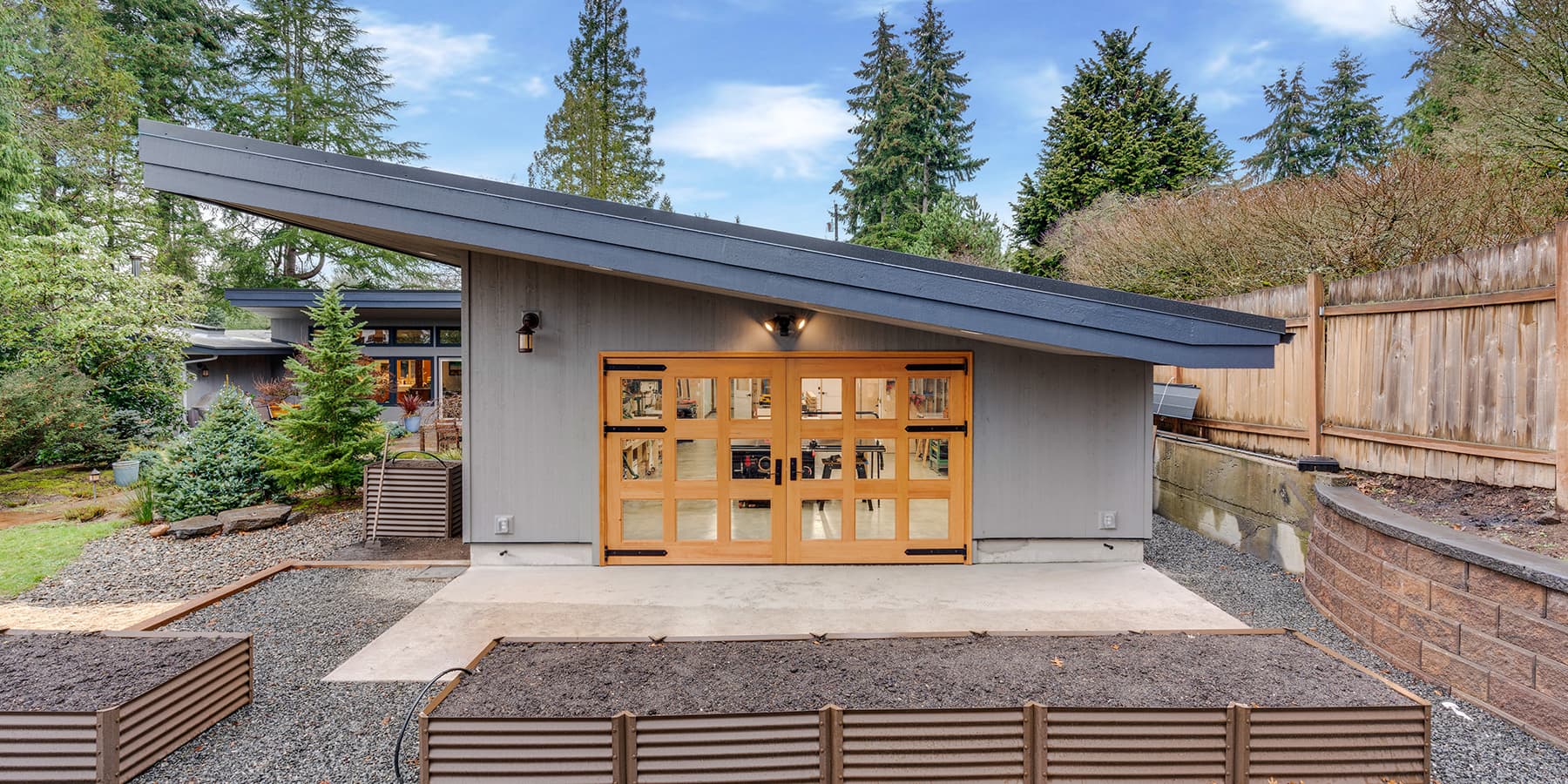 McIntyre Furniture woodshop exterior view featuring closed Douglas Fir Carriage Doors.