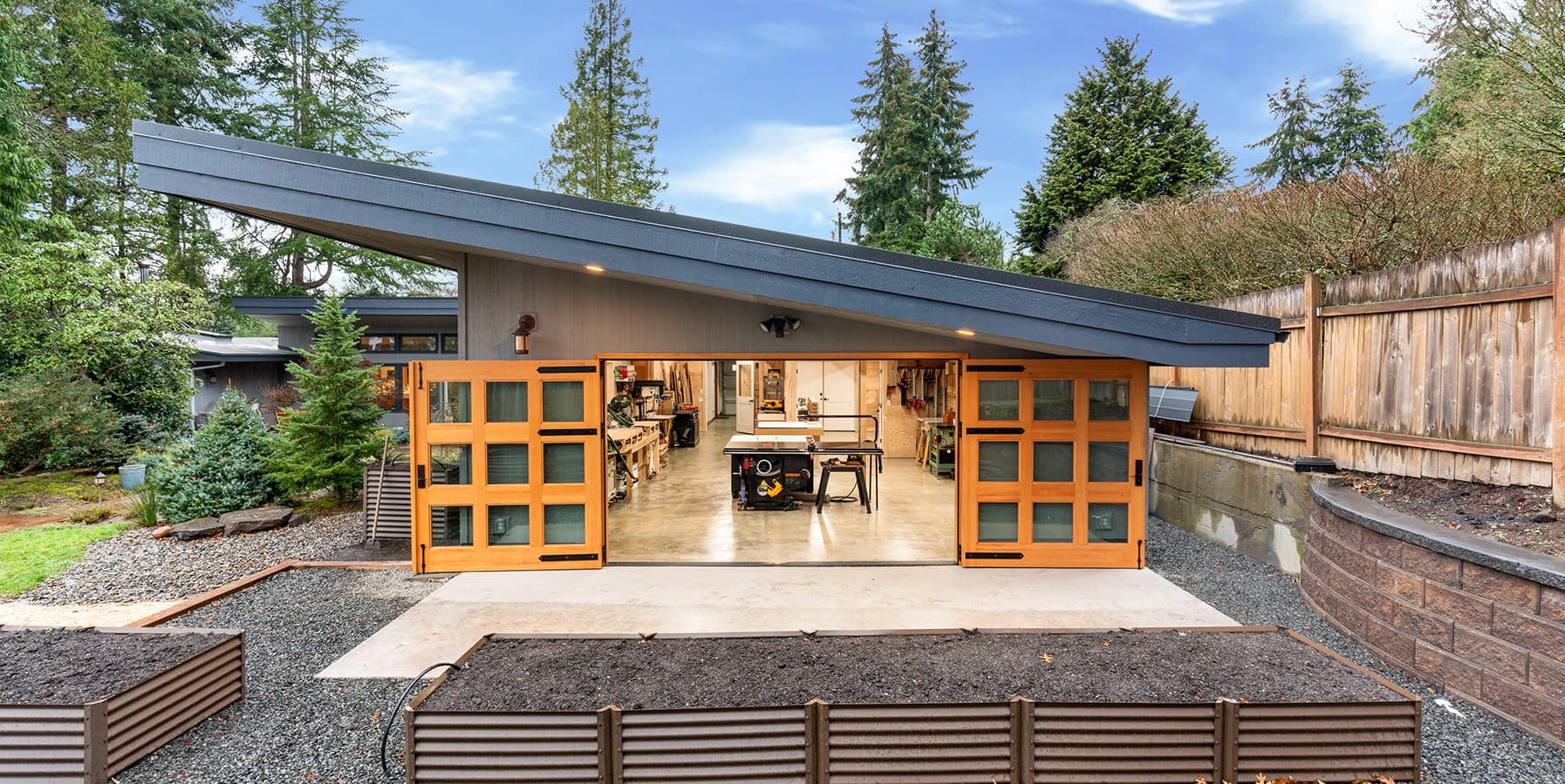 McIntyre Furniture woodshop exterior view featuring open Douglas Fir Carriage Doors.