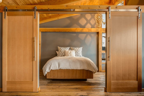 Solid Wood Bi-Opening Sliding Barn Doors Opening To A Light And Airy Bedroom With