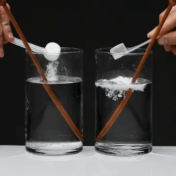 Two glasses, each with a dissolving effervescent tablet, stirred with chopsticks.