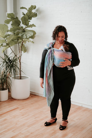 A mother carrying her baby in a colourful Tula RingSling.