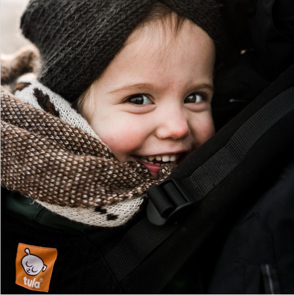 Een close-up van een kind dat in de camera lacht.