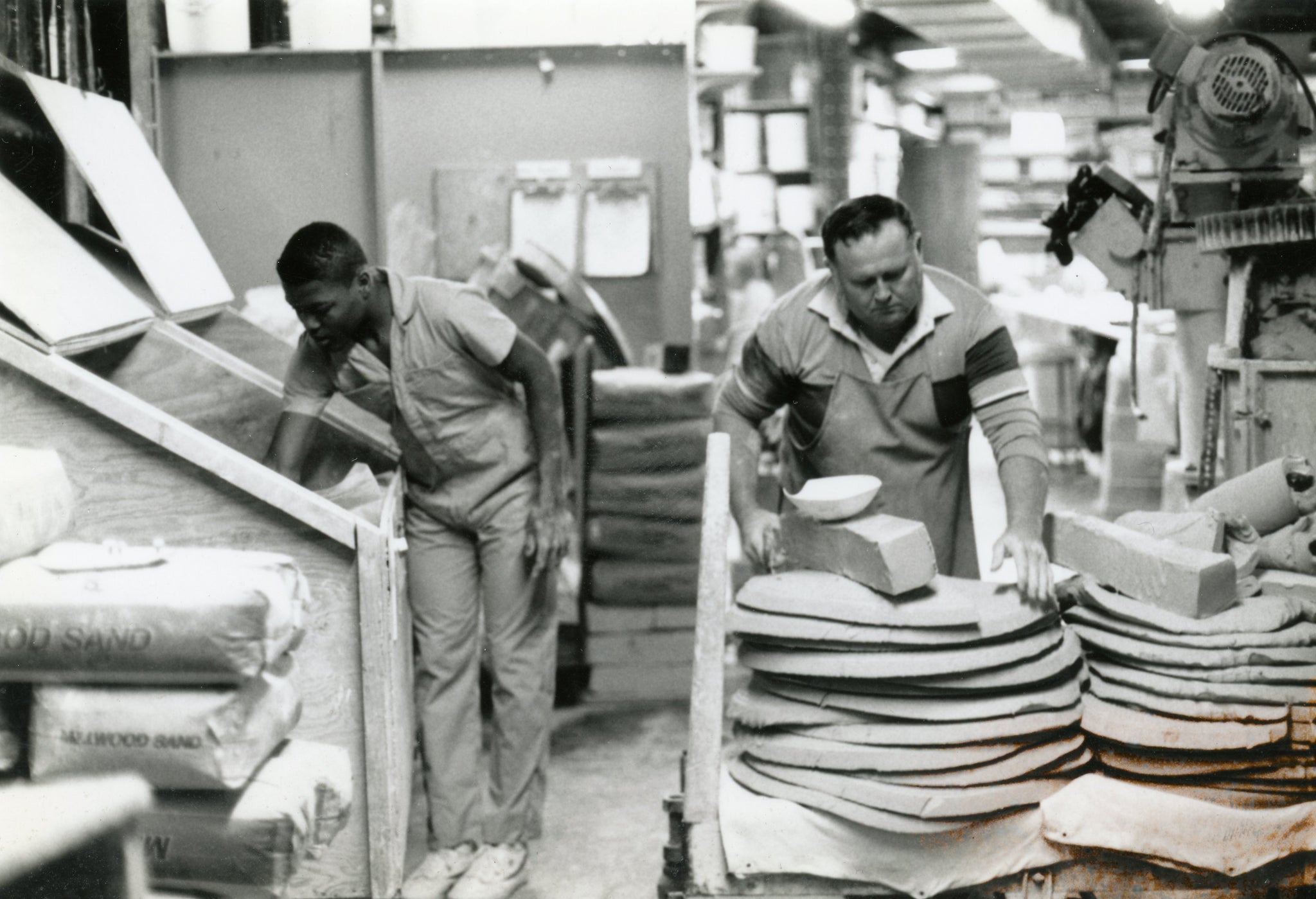 ewabic staffers Jerome (left), and John (right) circa 1983 pulling clay from the mixer.