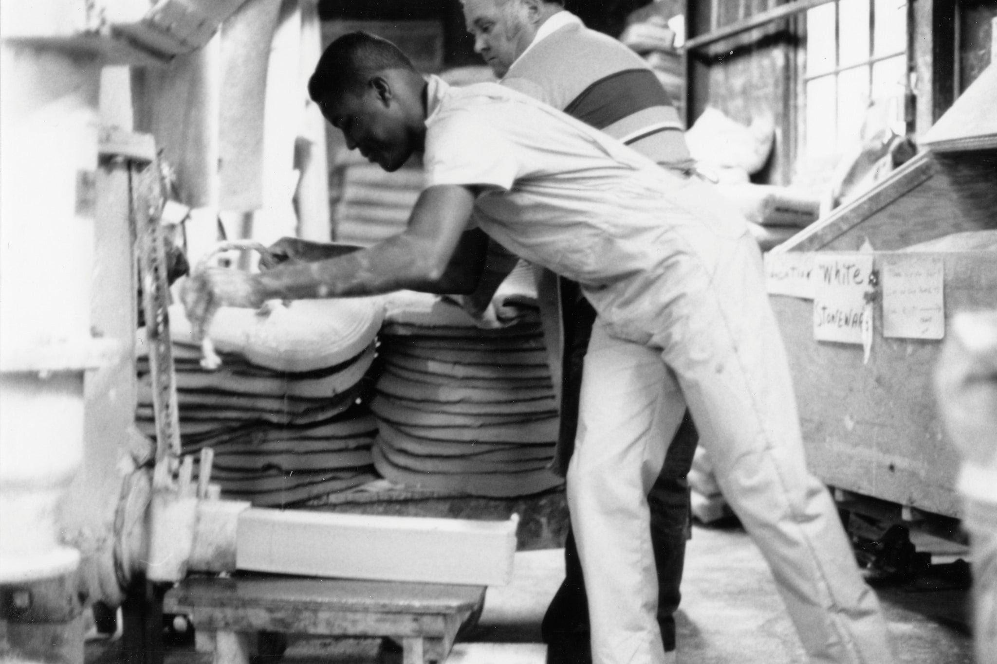 Jerome and John pulling finished clay logs from the pug mill.