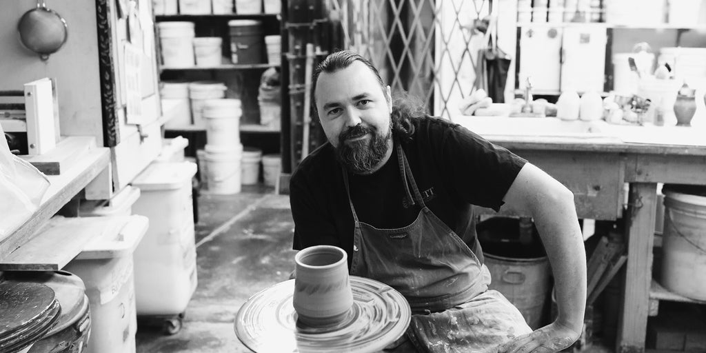 Pewabic potter Andrew K holds a wheel thrown piece he just finished. © Pewabic Pottery. Photo By Heather Nash