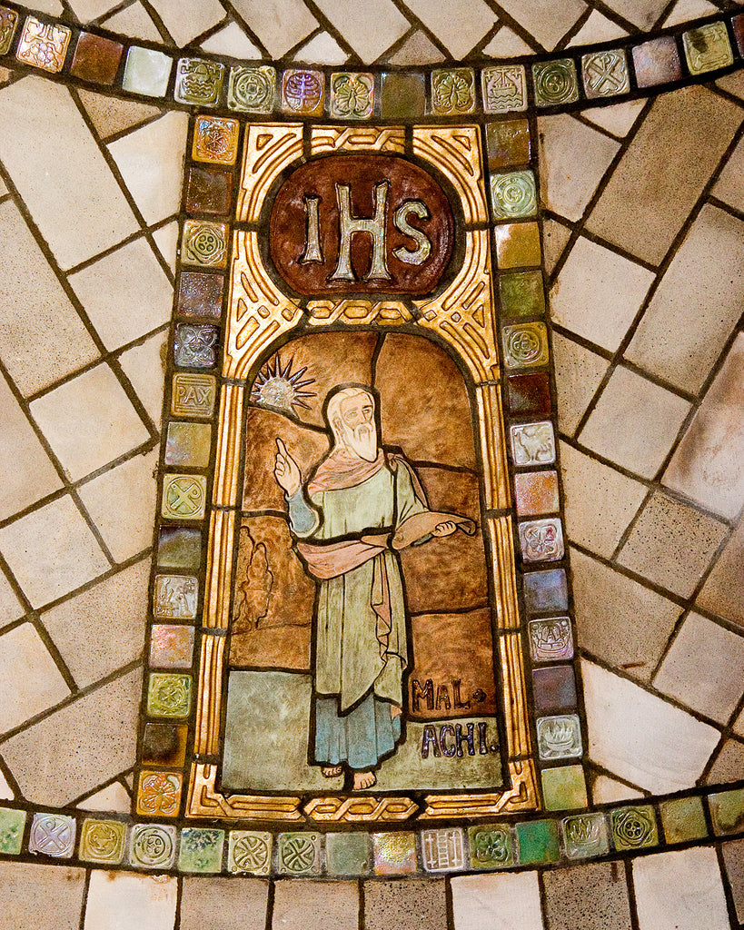 A tile depiction of the prophet Malachi surrounded by multi-colored iridescent glazed accent tiles.