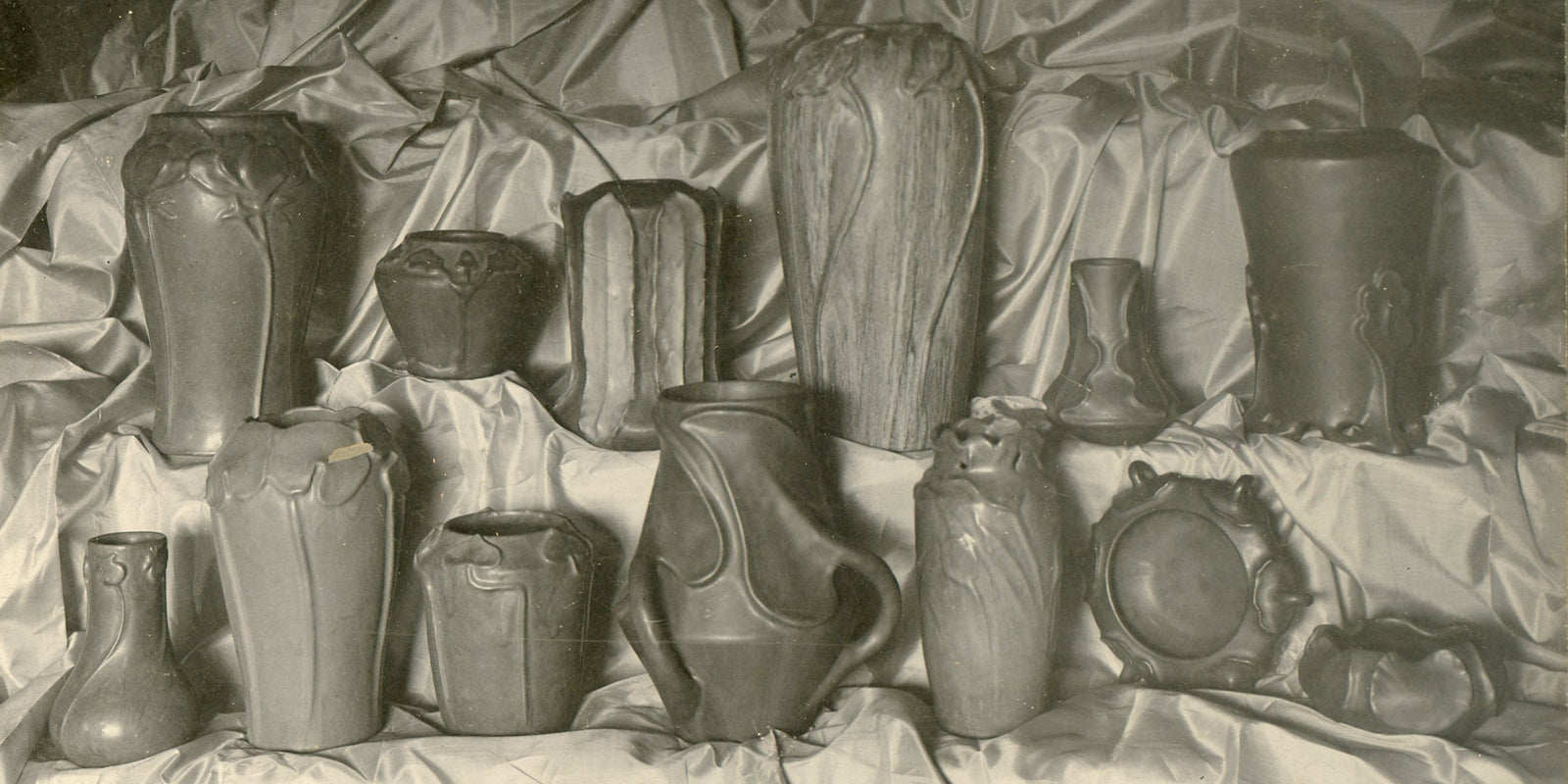 Sepia photo scan of a variety of early Pewabic vases at the Stable Studio in the early 1900s.