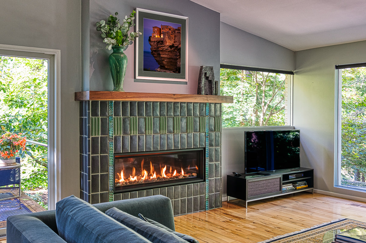 Straight on view of a custom Pewabic fireplace incorporating Midcentury Modern design elements with an Aurora Iridescent Saarinen-inspired tile border.