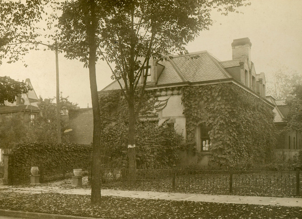 Sepia-toned exterior photo of the Stable Studio in Brush Park, circa 1903. The building's facade facing the street is covered in dense, climbing ivy.