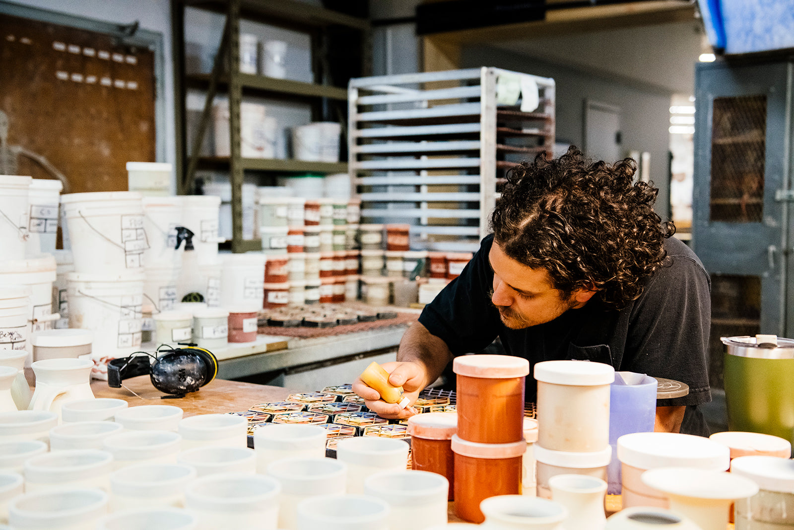 Pewabic artist Seamus hand-painting a batch of Hex Paperweights in the production space.