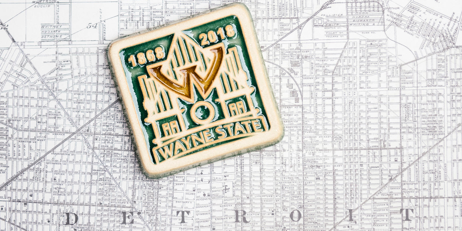 Our Wayne State University tile set on a black and white map of the city of Detroit.