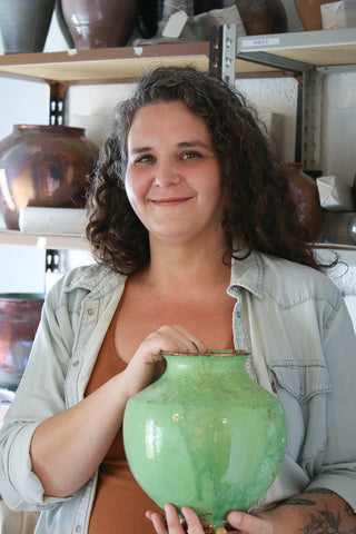 Pewabic Archivist and Education Director Annie holding one of Mary Chase’s early Iridescent pots from Pewabic’s archival collection.