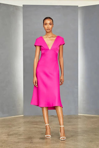 Model is wearing a short-sleeved v-neck midi dress in fuschia (but it is available in black!)