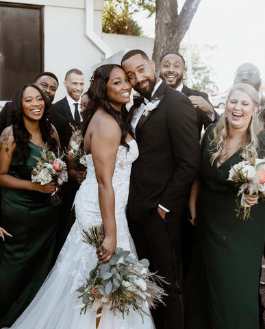 Bride and groom posing with bridal party in backyard