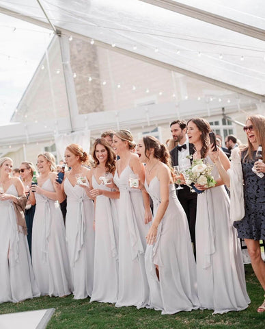 Bridesmaids standing under wedding tent during wedding reception