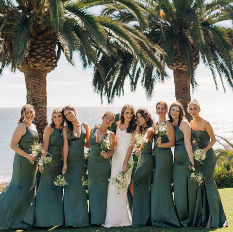 Bride and bridesmaids posing in front of palm trees