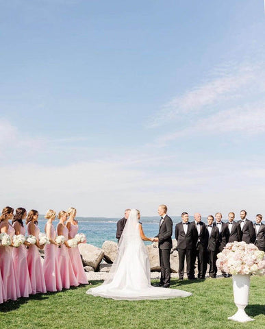 Bride and groom being wed surrounded by bridal party