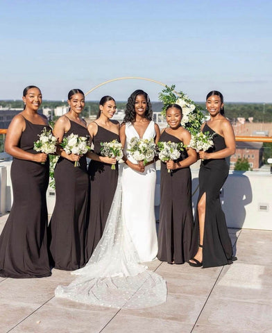 Bride in white dress standing with five bridesmaids in black dresses
