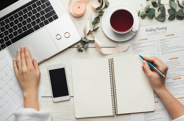 A person adding digital information to their DIY wedding planner.