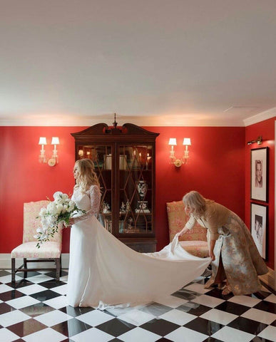 Bridesmaid holding bride's dress tail