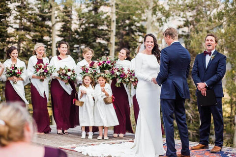 Couple getting married with bridal party and flower girls standing around