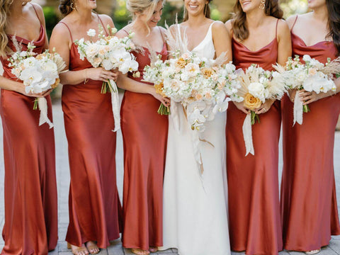 Bride in white slip wedding dress with five bridesmaids in red dresses