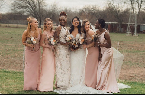 Bride and bridesmaids posing in a field at Gruene Estates in San Antonio