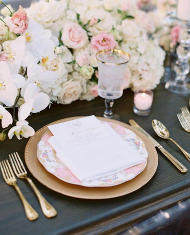 Ivory and gold table settings at wedding