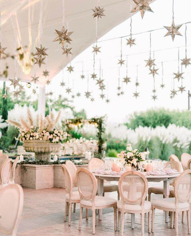 Wedding reception venue outdoors decorated in gold and ivory