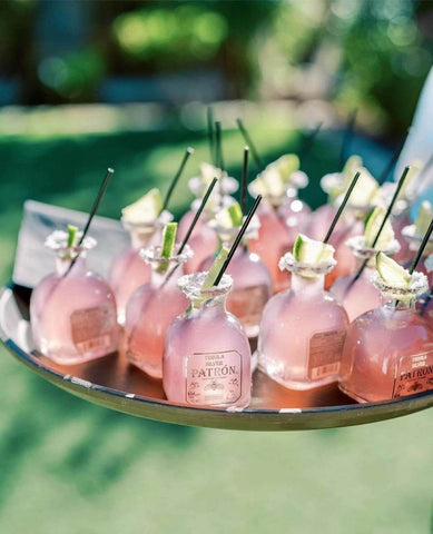 Small Patron bottles with straws on a tray