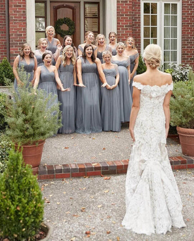 Bridesmaids reacting to bride's dress. One bridesmaid is pregnant.