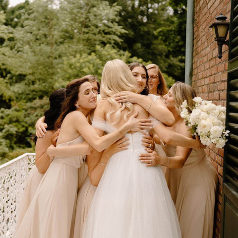 Bride hugging group of bridesmaids